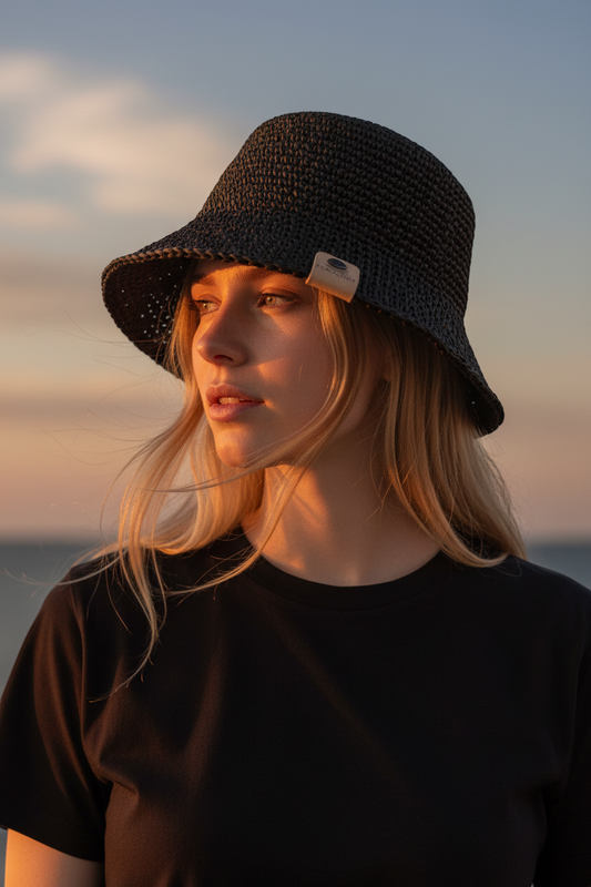 J.CROCHET black handcrafted raffia bucket hat with a classic silhouette and subtle branded tab detail.
